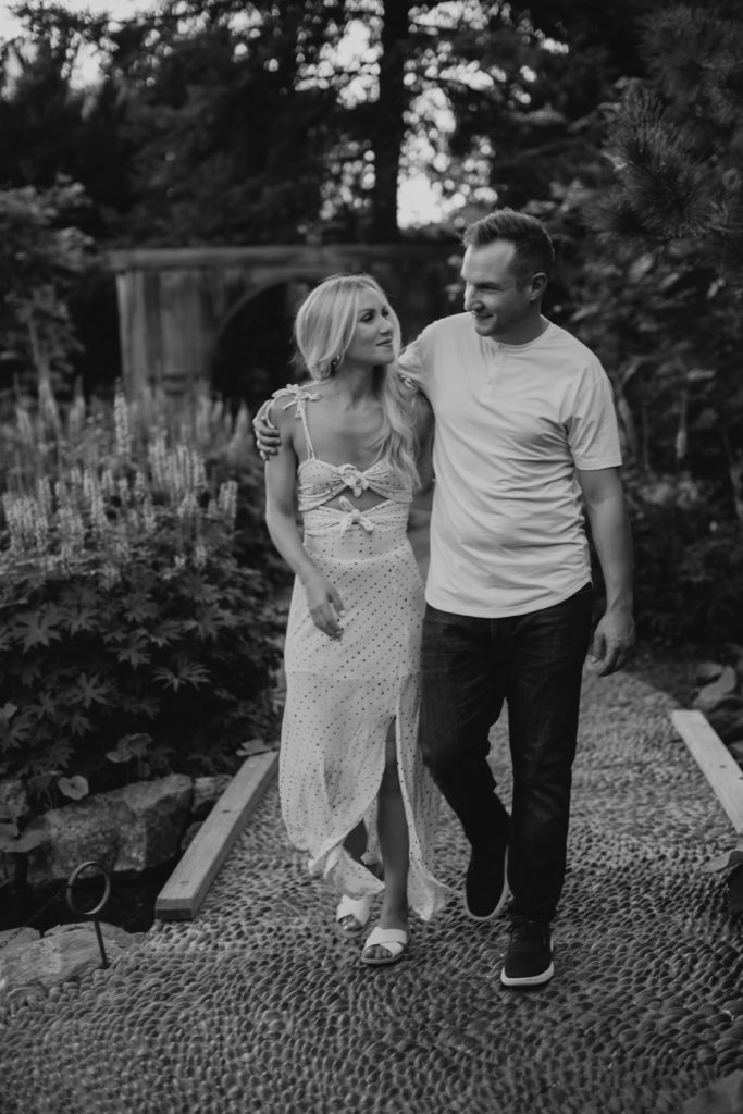 couple walking along pathways in Denver botanic garden engagement photos