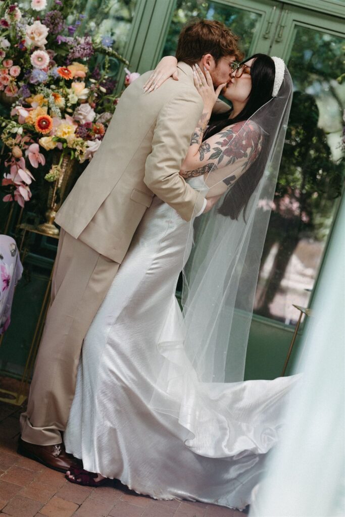 Couple kissing during wedding inside Denver Botanic Gardens 