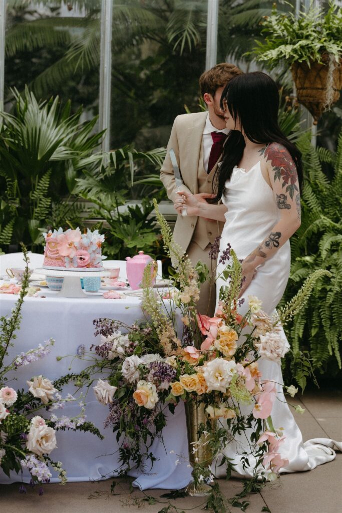 Couple cutting cake at Denver Botanic gardens wedding