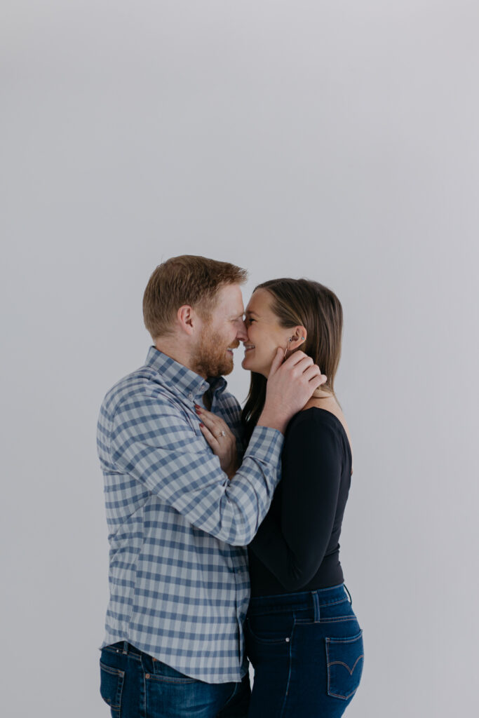 couple standing against white backdrop in studio