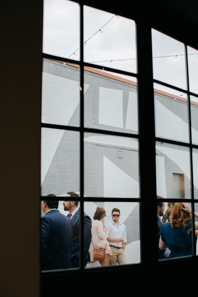 looking outside through large, glass industrial windows of denver wedding venue