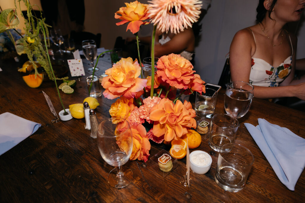 orange flowers sitting on top of wedding reception table