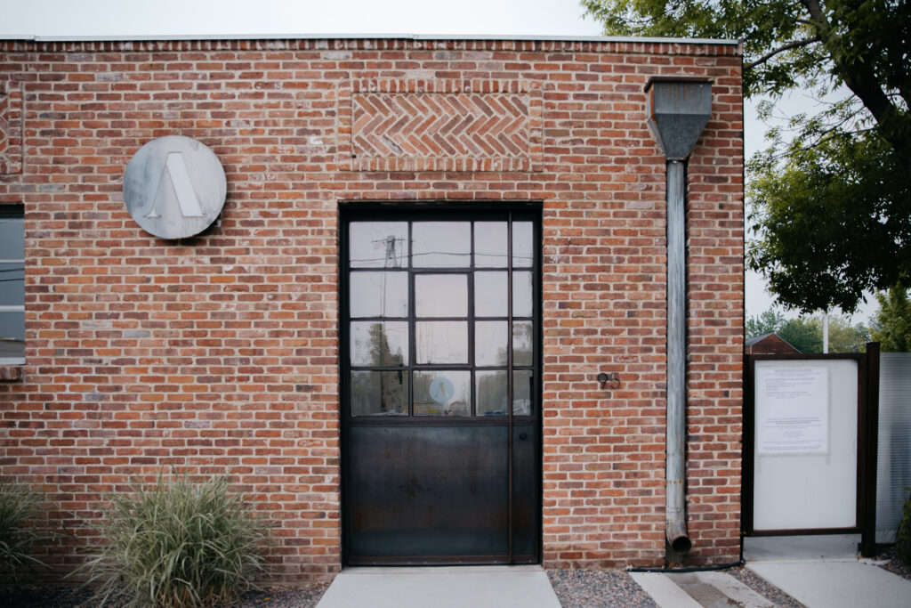 Large outdoor industrial door at the front of brick art gallery