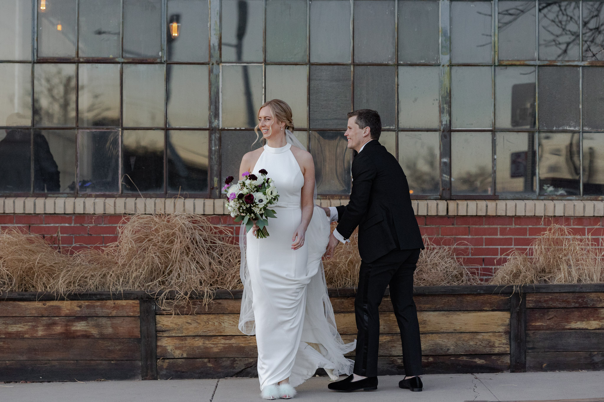 Bride and groom standing in front of Moss during Denver wedding portraits
