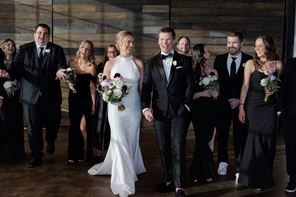 Wedding party candidly laughing and walking during Denver wedding photos at Moss venue