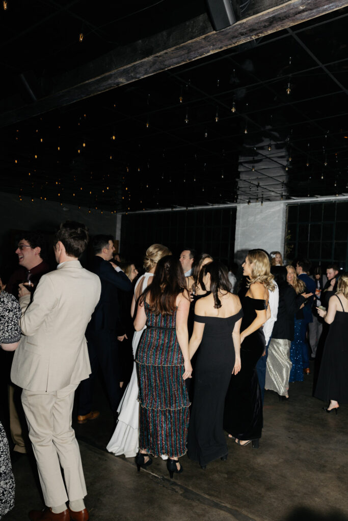 Group of wedding guests on dance floor of industrial, urban Denver wedding locations and venue Moss