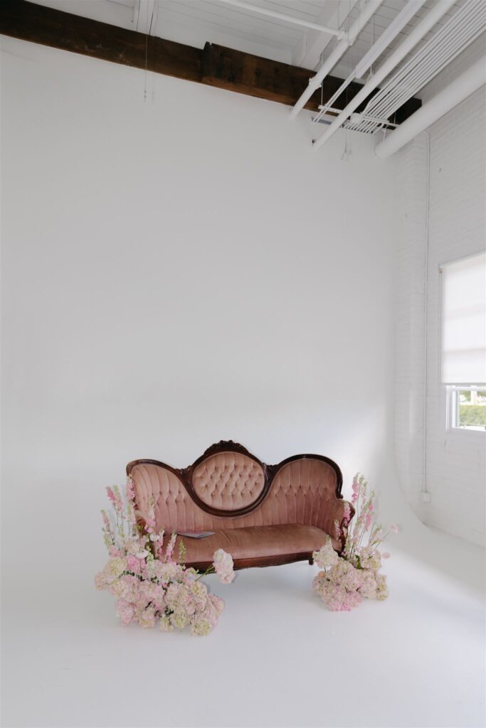 vintage couch decorated with pink florals in photo studio