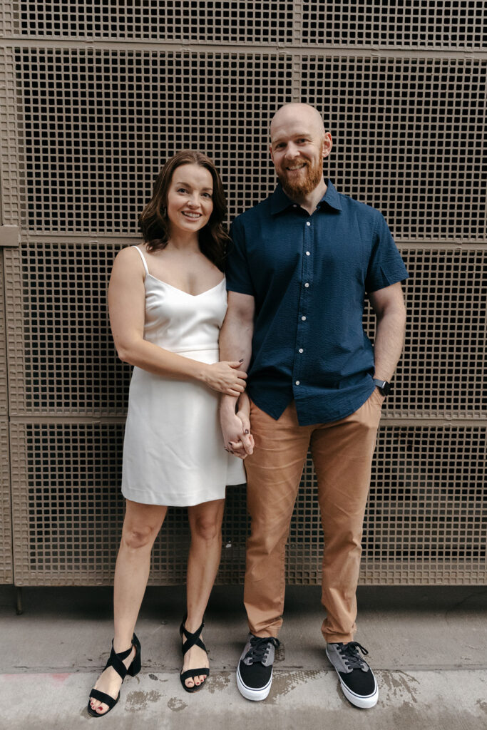 Couple stands in front of good places to take pictures in Denver for Downtown Denver engagement photos