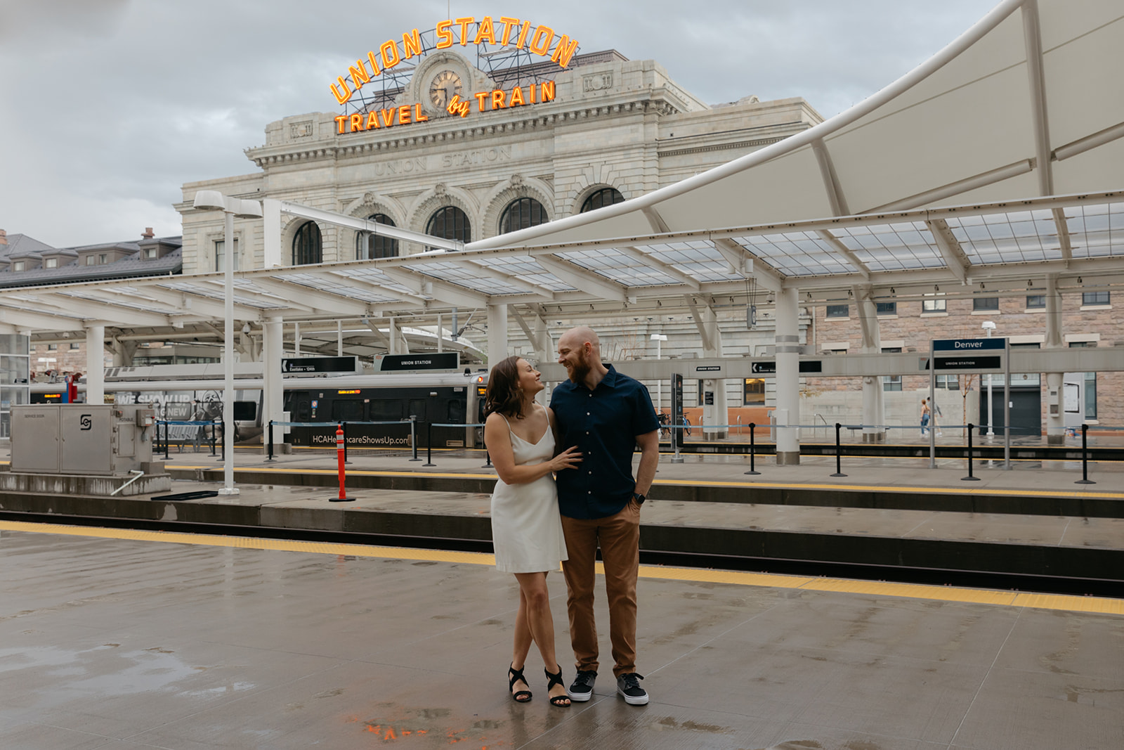 Couple stands in front of Union Station during Denver engagement photos