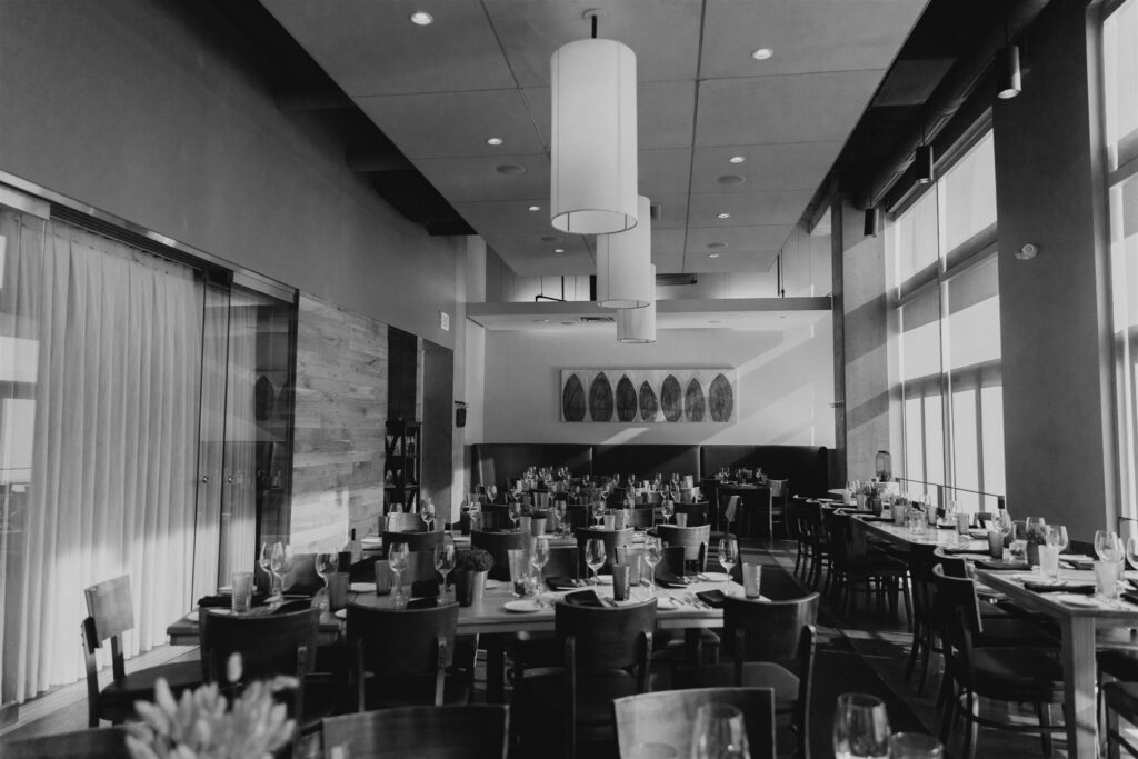 a private dining room inside of Coohills Restaurant in Denver filled with tables and wine glasses with sunlight pouring through windows