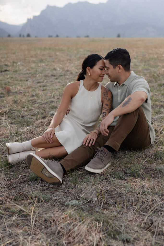Couple sitting on ground during Boulder Flatirons engagement session