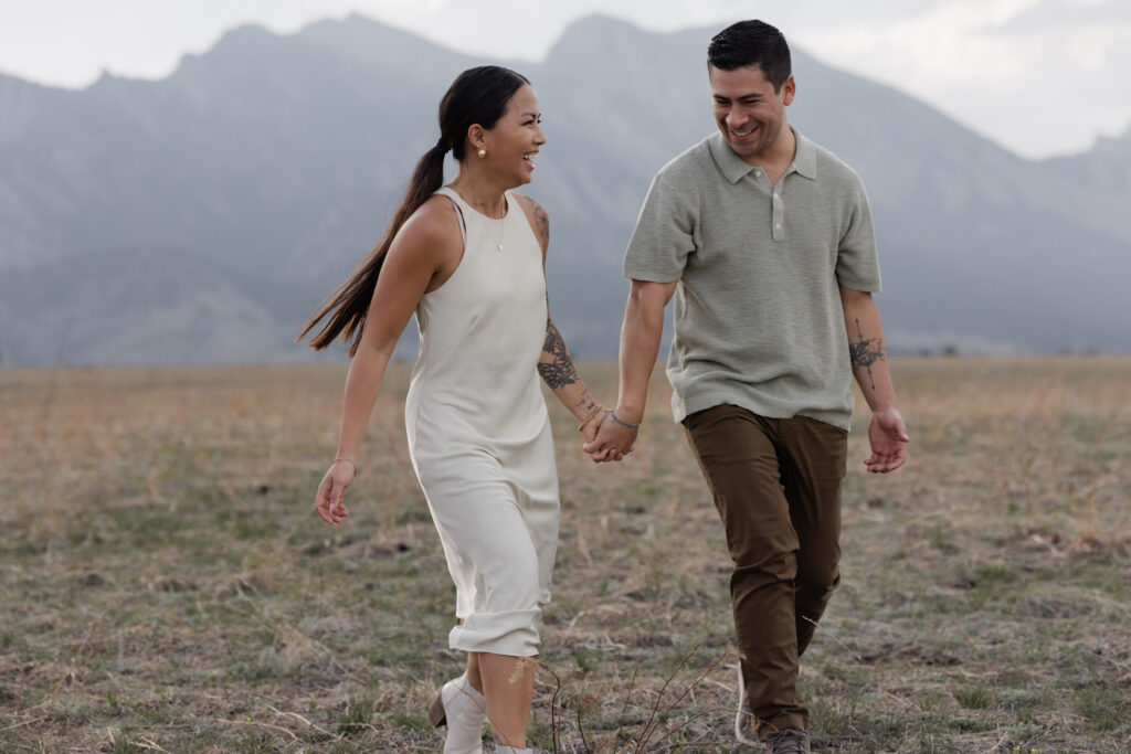 Couple walking in front of Boulder Flatirons during Colorado engagement session