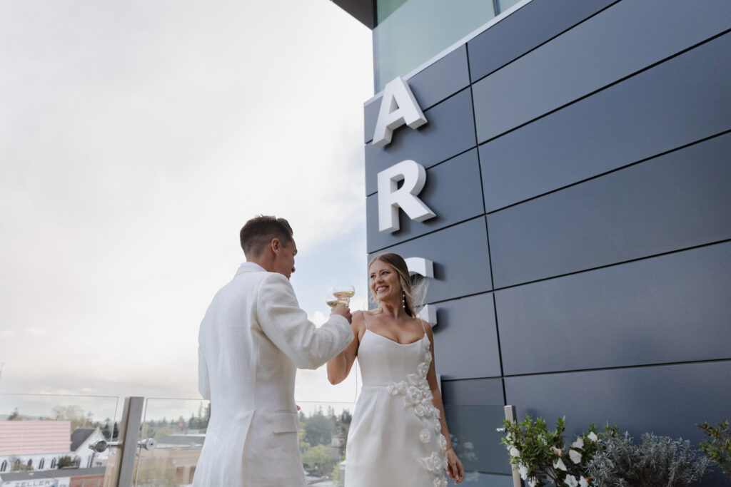 Bride and groom toast on rooftop of Archer hotel during wedding welcome celebration 