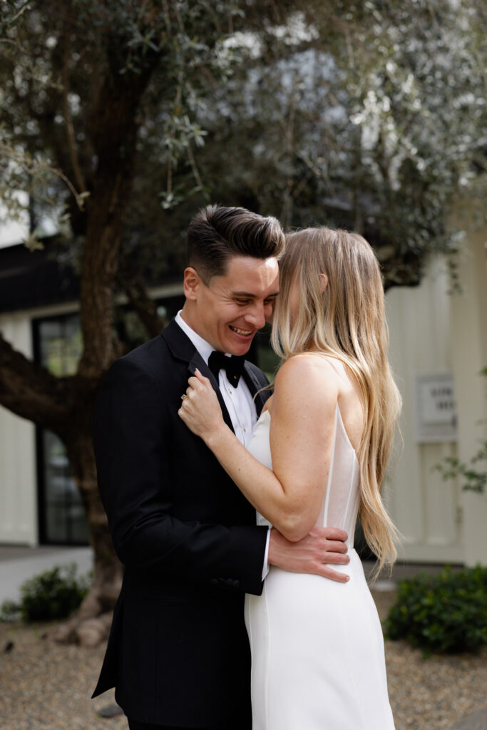 Groom candidly laughs during wedding photos at the Estate Yountville