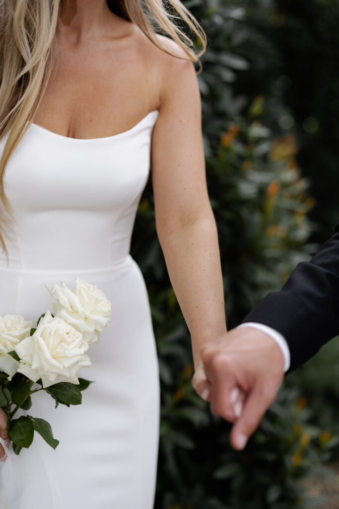 Up-close view of groom holding bride's hand during wedding photos at the Estate Yountville