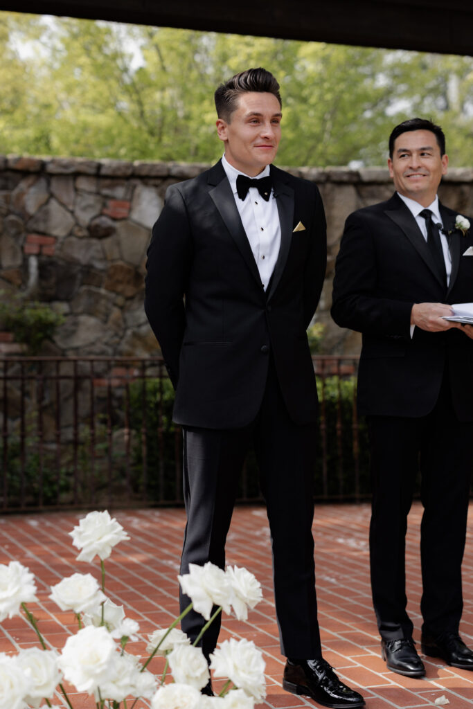 Groom watches as bride walks down aisle during wedding at the Estate Yountville