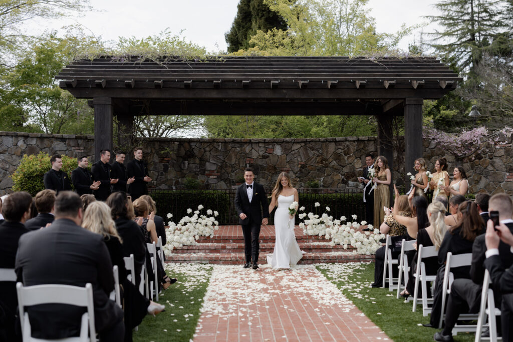 Bride and groom departing courtyard wedding ceremony at the Estate Yountville