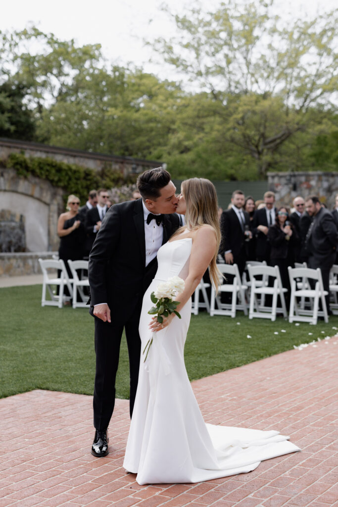 Bride and groom kissing in courtyard post wedding ceremony at the Estate Yountville