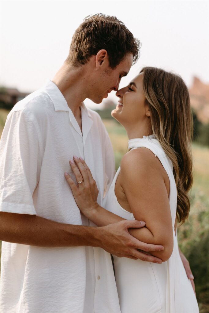 Couple goes nose to nose during Denver engagement photos at Cheesman park