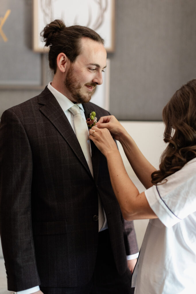 Bride adjusts groom's flowers at Four Seasons