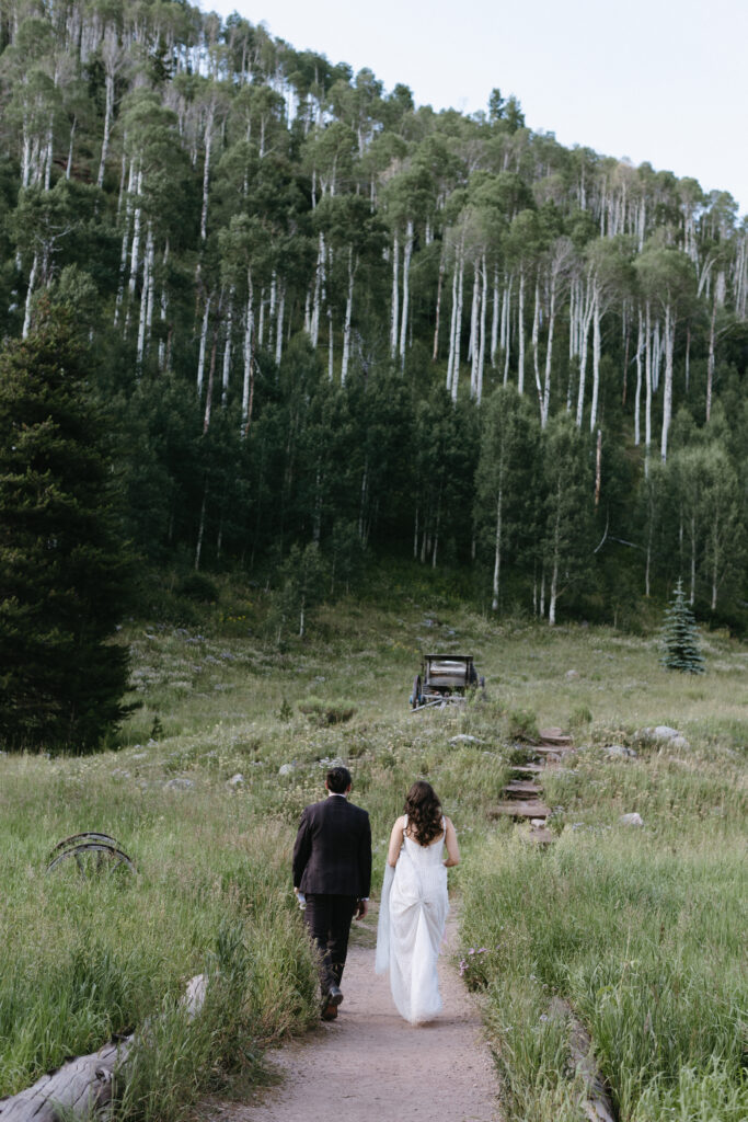 Couple walking towards aspen tress at Piney River Ranch elopement