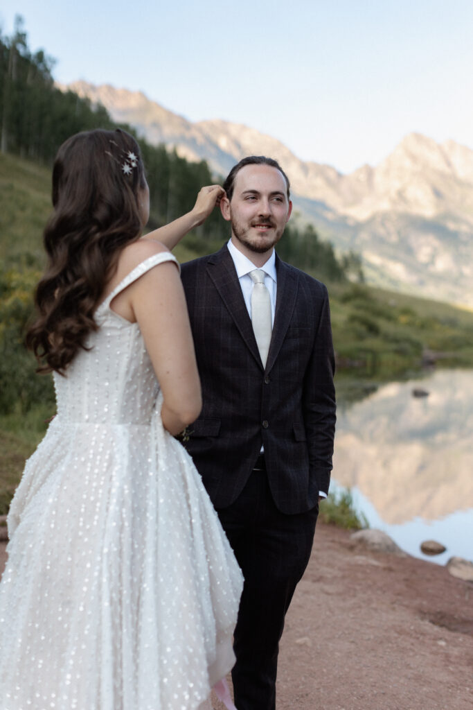 Bride fixing groom's hair during wedding photos at Piney River Ranch elopement