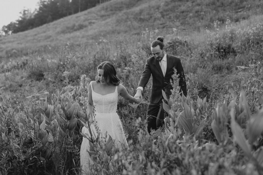 Candid moment of bride and groom walking hand in hand during Colorado elopement at Piney River Ranch