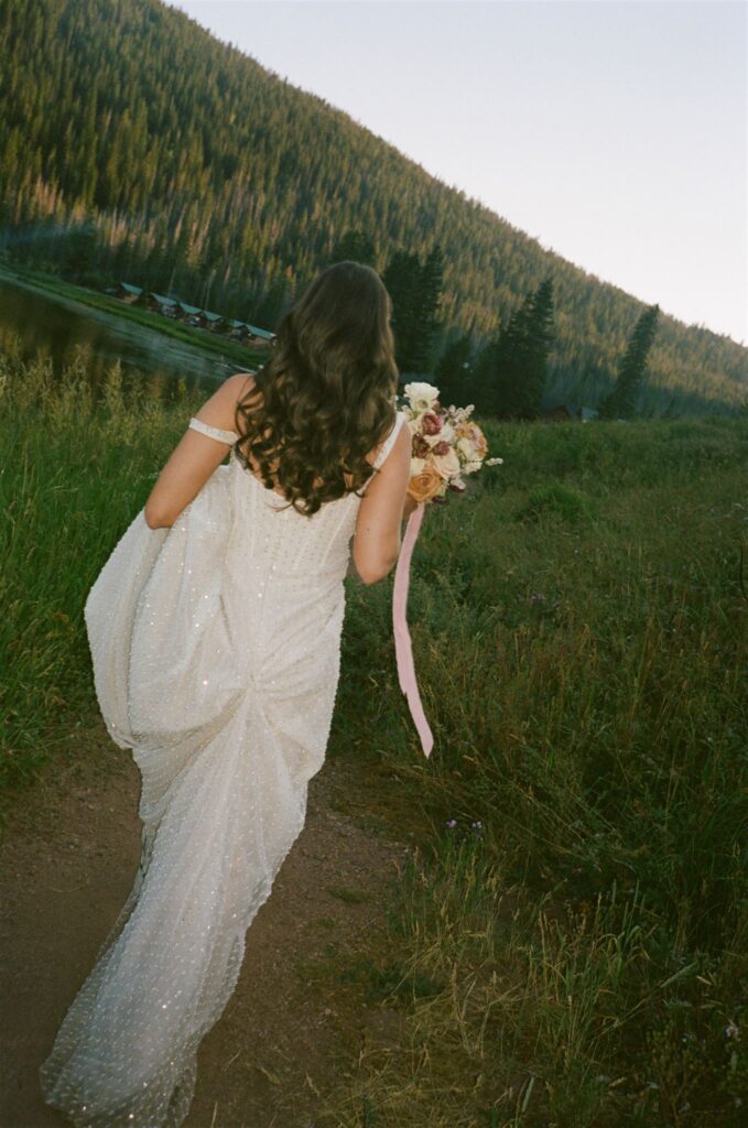 Bride walking in grassy area during Piney River Ranch elopement