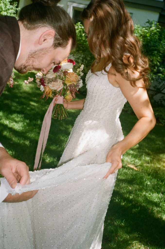 Groom fixing bride's dress during Colorado elopement at Four Seasons Vail 