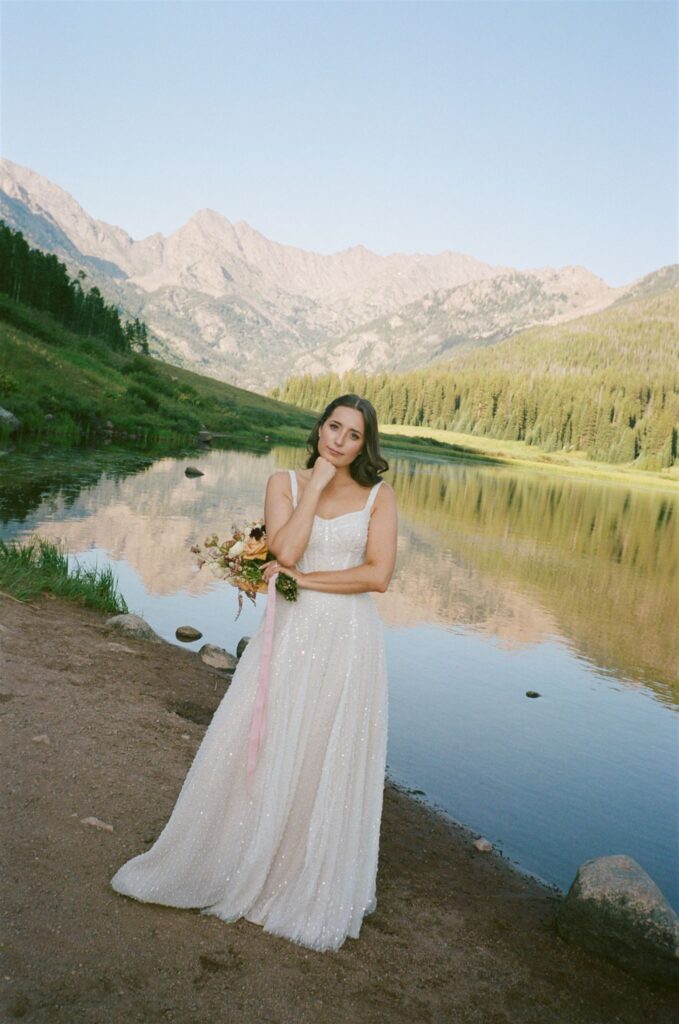 Bride poses for photos on 35mm film camera at Piney River Ranch elopement